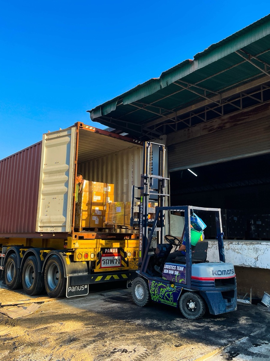 Forklift loading palletized cargo into a container at the dock door