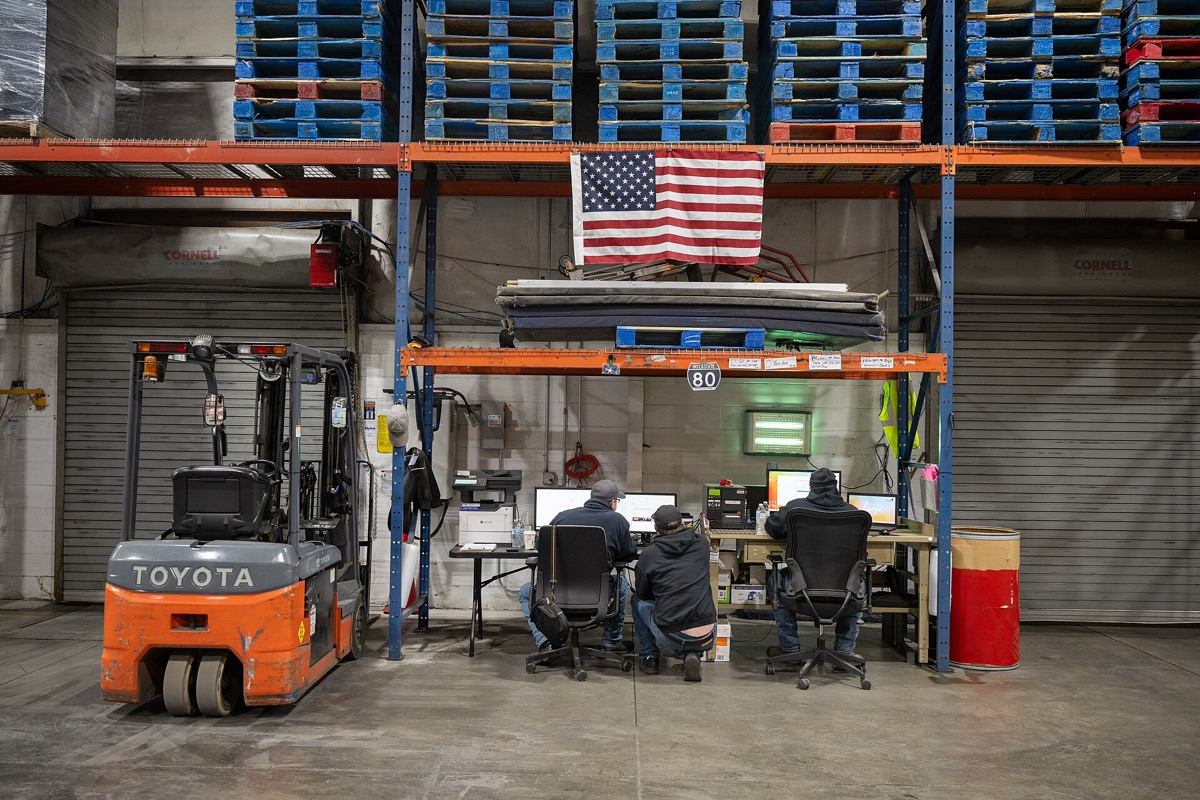 Operations desk on the warehouse floor with team at computers