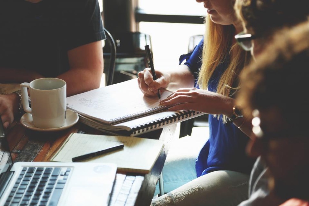 Team working together around a table with notebooks and a laptop