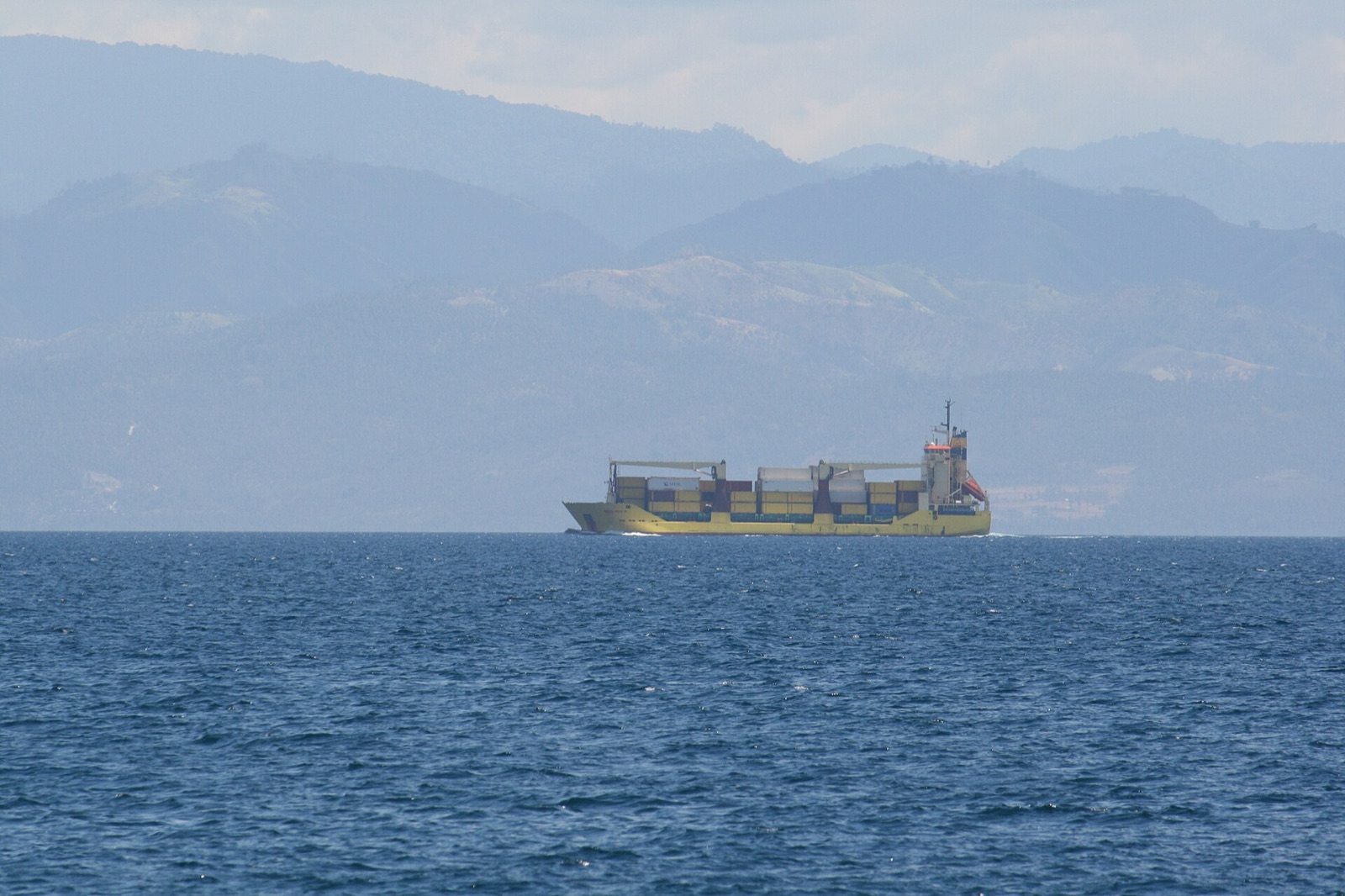 Container vessel underway across open tropical water